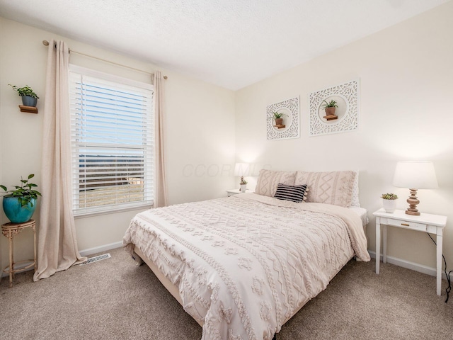 carpeted bedroom featuring a textured ceiling and baseboards