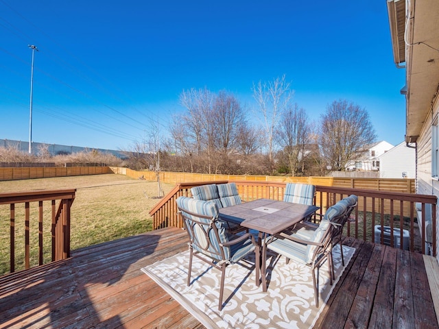 wooden deck featuring outdoor dining area, a yard, and a fenced backyard