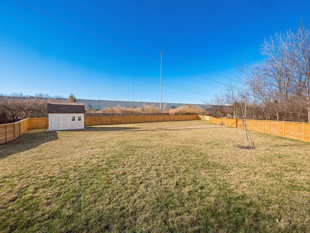 view of yard featuring a storage unit, an outbuilding, and a fenced backyard