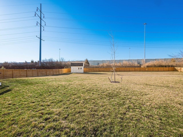 view of yard featuring an outdoor structure, a fenced backyard, and a storage shed