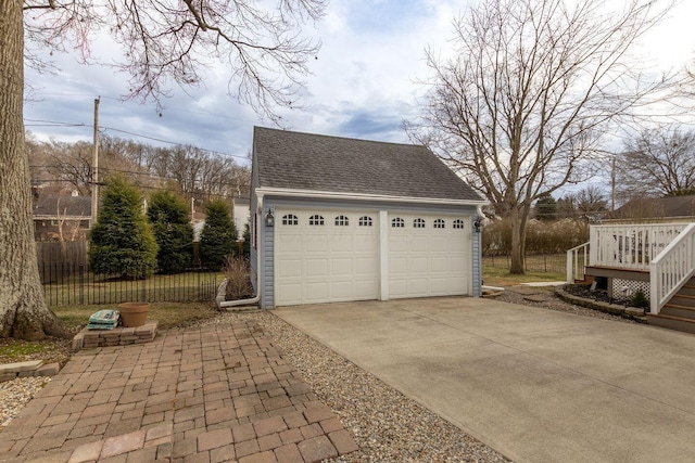 detached garage featuring fence