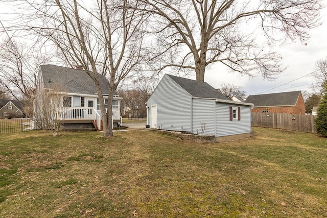 rear view of property with an outbuilding, a yard, a wooden deck, and fence