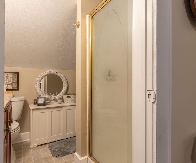 bathroom with lofted ceiling, a shower stall, toilet, and vanity