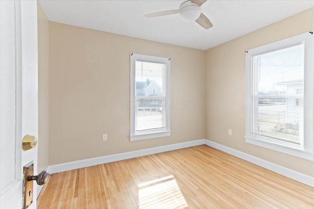 unfurnished room with light wood-style floors, plenty of natural light, and baseboards