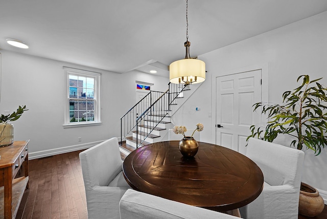 dining area featuring dark wood finished floors, stairway, and baseboards