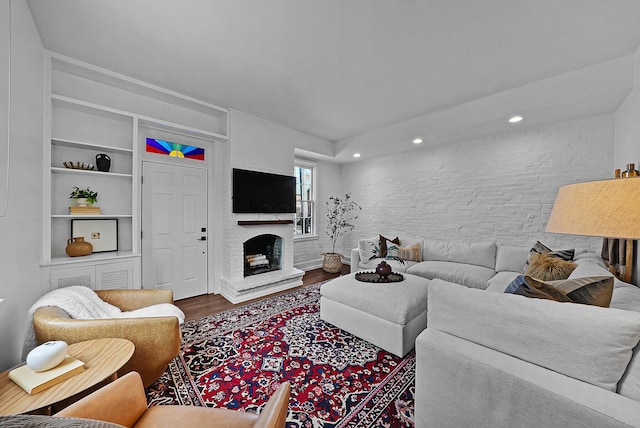 living area with a large fireplace, wood finished floors, and recessed lighting