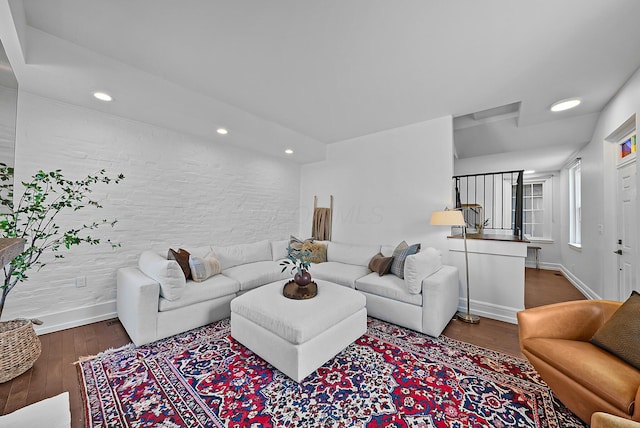 living area with baseboards, wood finished floors, and recessed lighting