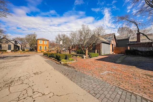 view of front of home with a residential view and fence