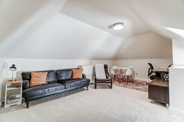 sitting room featuring vaulted ceiling with skylight, carpet, and baseboards