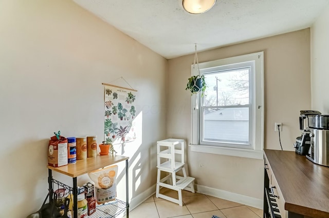 interior space featuring baseboards and light tile patterned floors