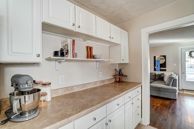 kitchen with hardwood / wood-style flooring, white cabinetry, open shelves, and a textured ceiling