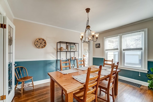 dining space with arched walkways, dark wood-style flooring, visible vents, and crown molding