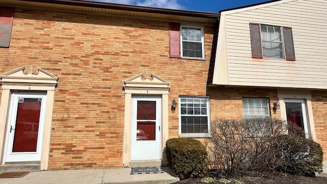 doorway to property with brick siding