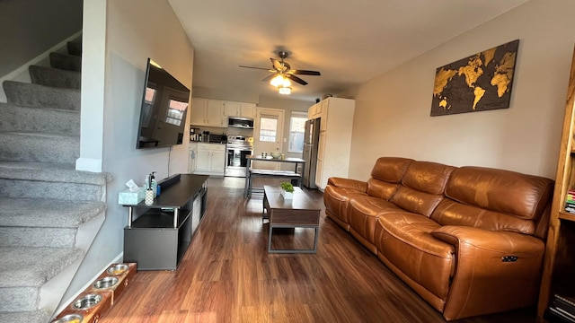 living area featuring stairs, a ceiling fan, and dark wood-style flooring