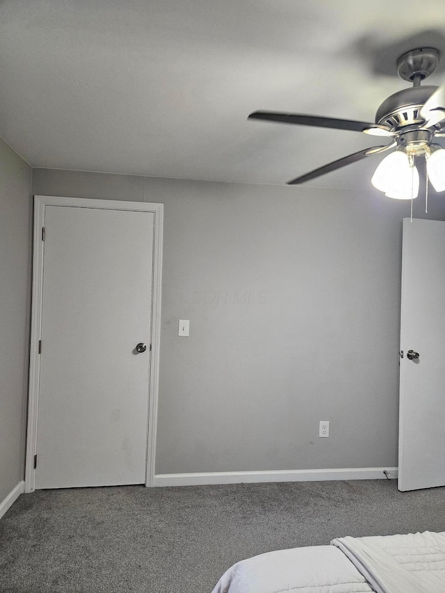 unfurnished bedroom featuring carpet floors, baseboards, and a ceiling fan