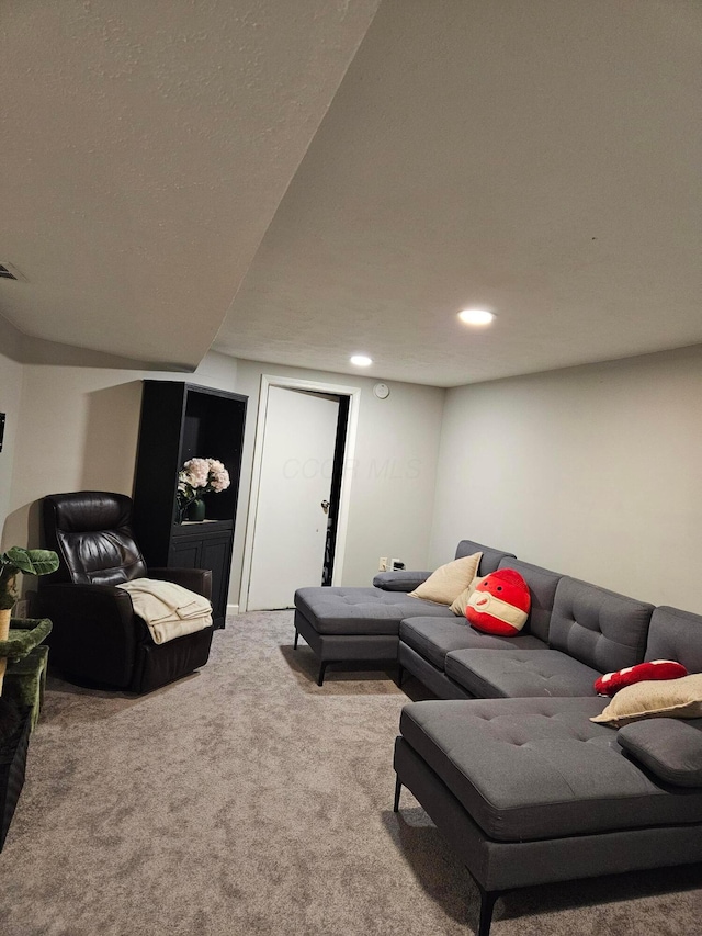 living area featuring carpet, a textured ceiling, and recessed lighting