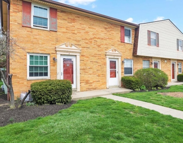 multi unit property featuring brick siding and a front lawn