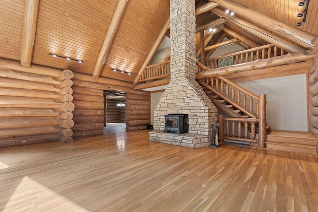 unfurnished living room with high vaulted ceiling, wood finished floors, wood ceiling, beamed ceiling, and a wood stove