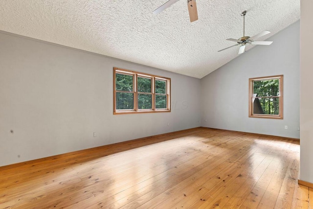 unfurnished room with lofted ceiling, wood-type flooring, a textured ceiling, and a ceiling fan