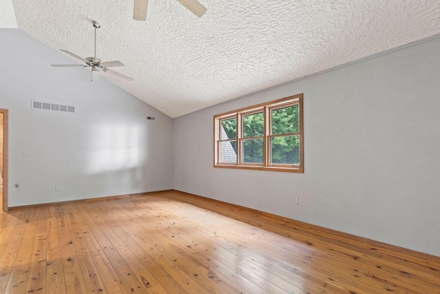 unfurnished room with a textured ceiling, visible vents, a ceiling fan, vaulted ceiling, and light wood finished floors