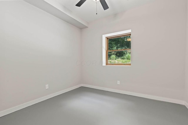 unfurnished room featuring finished concrete flooring, baseboards, and a ceiling fan