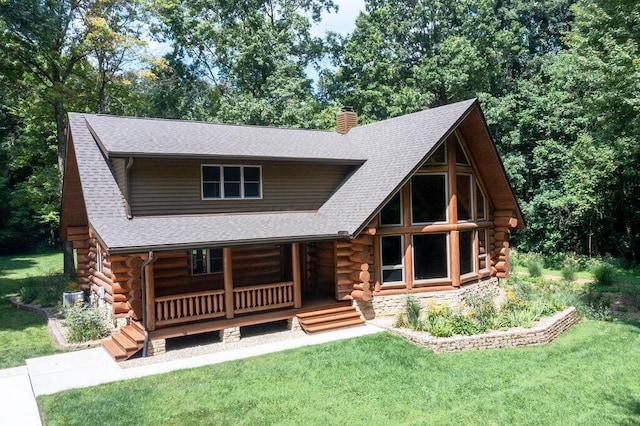 cabin with a front lawn, log siding, a porch, and a shingled roof