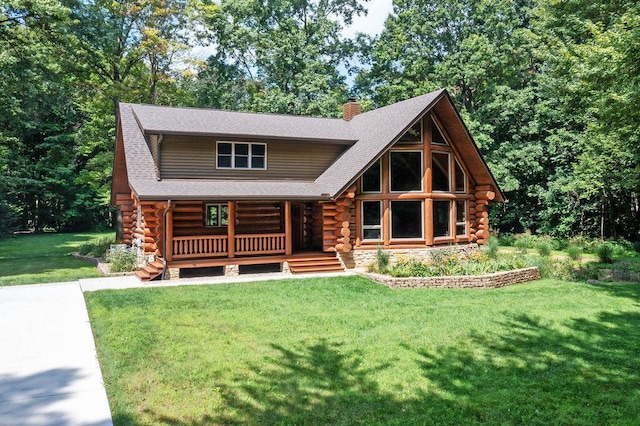 cabin with covered porch, log exterior, and a front yard