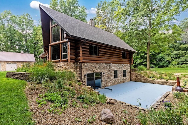 view of home's exterior featuring a patio area, stone siding, a chimney, and log exterior