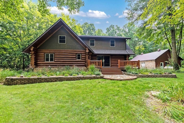 view of front of home featuring a deck, a front yard, and log siding