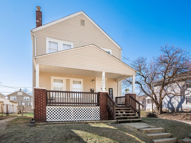 back of house with a yard, a porch, a chimney, and fence