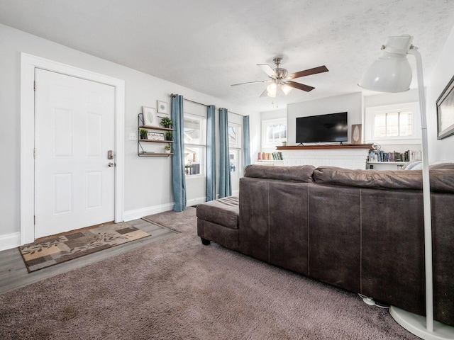 living room with baseboards, ceiling fan, and carpet floors