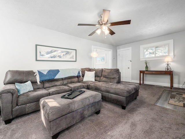 carpeted living area with baseboards and ceiling fan