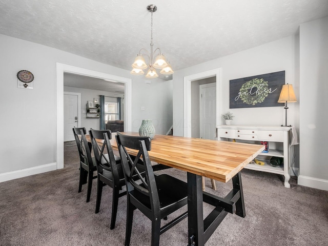 dining room featuring an inviting chandelier, dark carpet, a textured ceiling, and baseboards