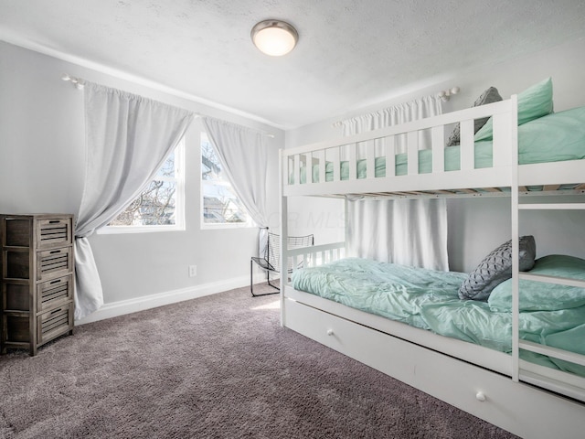 bedroom with a textured ceiling, baseboards, and carpet floors