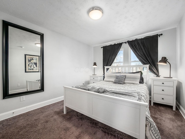 bedroom featuring dark colored carpet, baseboards, and a textured ceiling