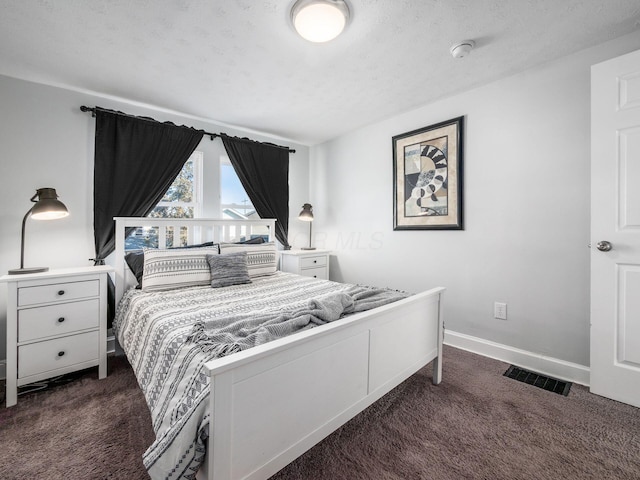 bedroom with visible vents, baseboards, dark colored carpet, and a textured ceiling