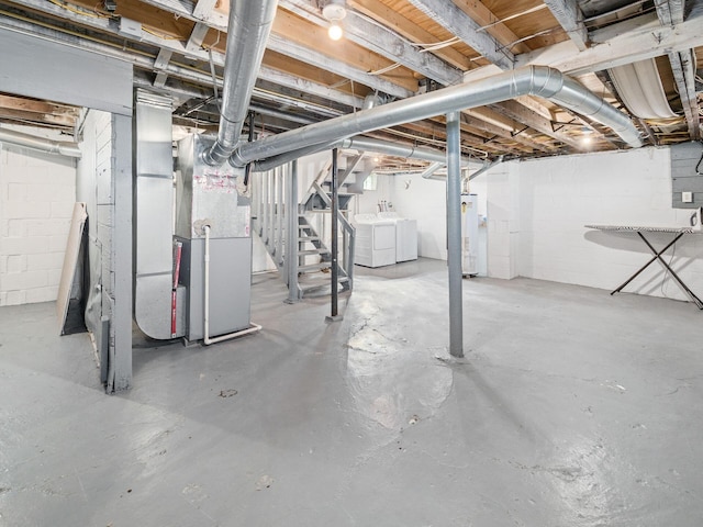 unfinished below grade area featuring gas water heater, heating unit, and washer and clothes dryer