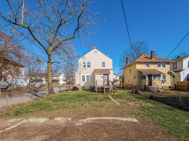 back of house featuring a lawn and a fenced backyard