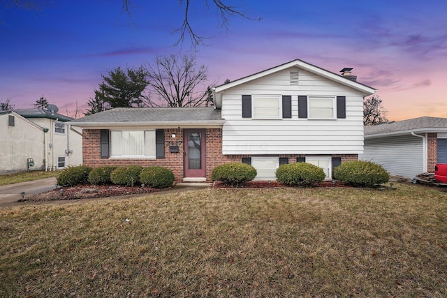 tri-level home featuring brick siding and a front yard