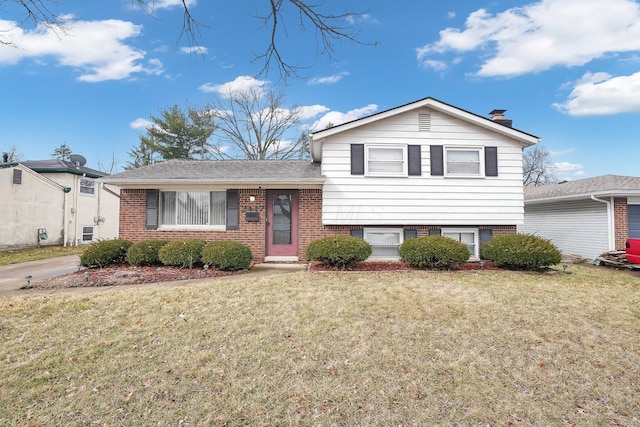 split level home featuring brick siding and a front lawn