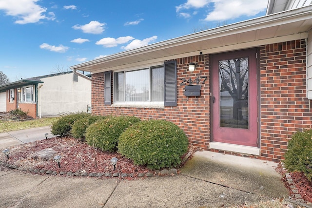 view of exterior entry featuring brick siding