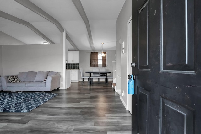 entrance foyer featuring dark wood finished floors, lofted ceiling with beams, and baseboards
