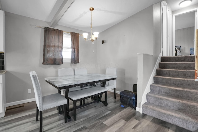 dining area featuring baseboards, stairway, wood finished floors, beam ceiling, and a notable chandelier