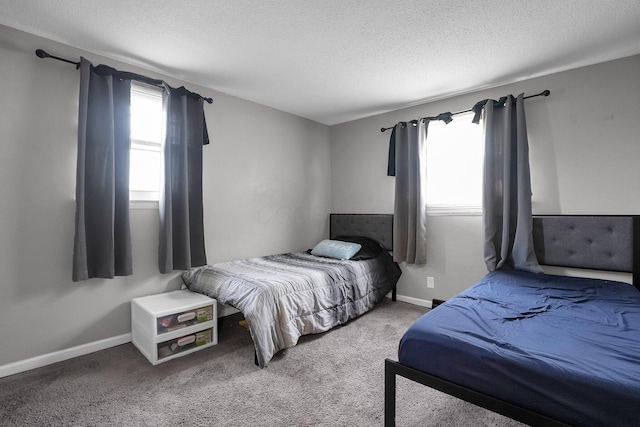 carpeted bedroom featuring a textured ceiling and baseboards
