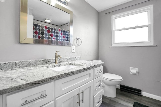 full bathroom with baseboards, a shower with shower curtain, toilet, wood finished floors, and vanity