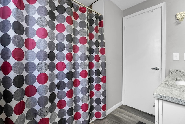 bathroom with a shower with curtain, vanity, and wood finished floors