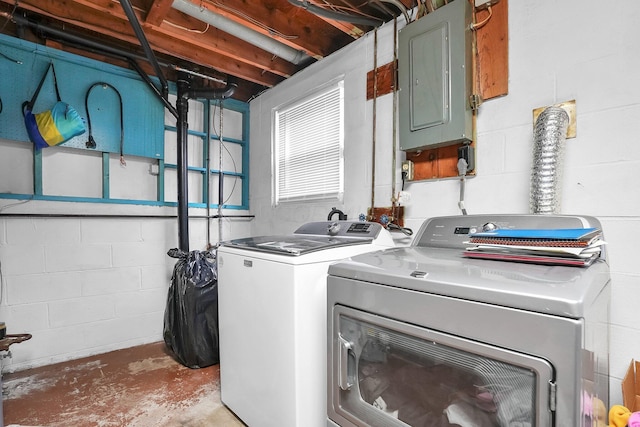 laundry area with laundry area, separate washer and dryer, electric panel, and concrete block wall