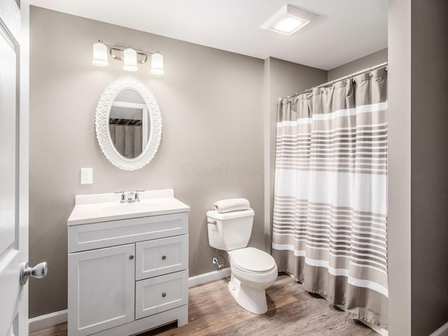 bathroom with toilet, wood finished floors, vanity, baseboards, and a shower with curtain