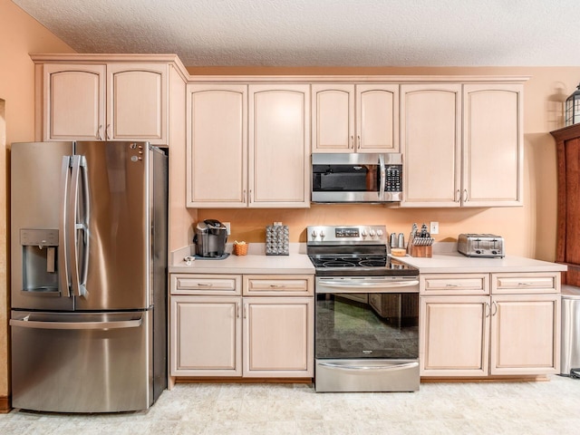 kitchen with light countertops, appliances with stainless steel finishes, and light brown cabinetry