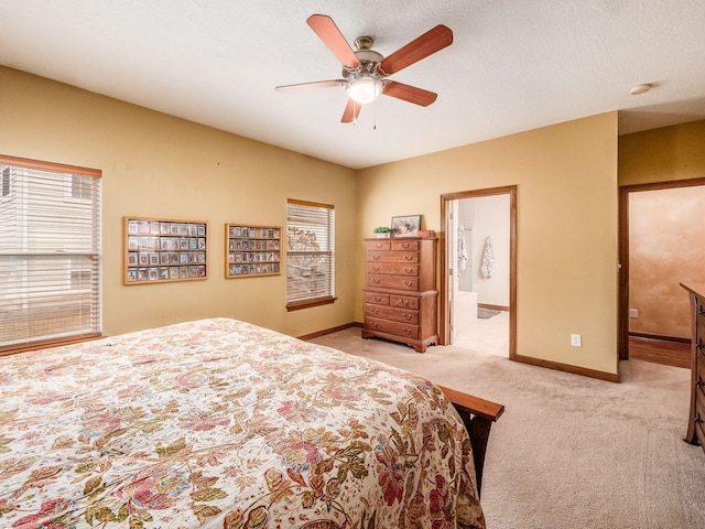 bedroom with light carpet, baseboards, connected bathroom, ceiling fan, and a textured ceiling